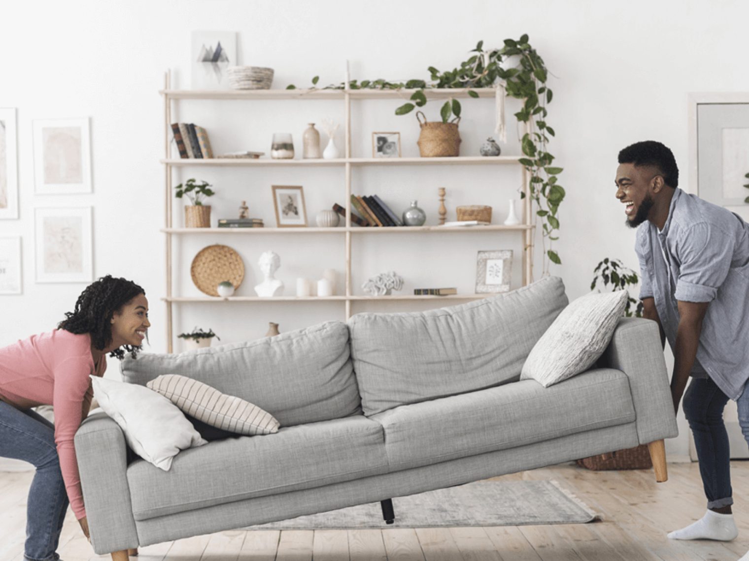 Couple moving gray couch.