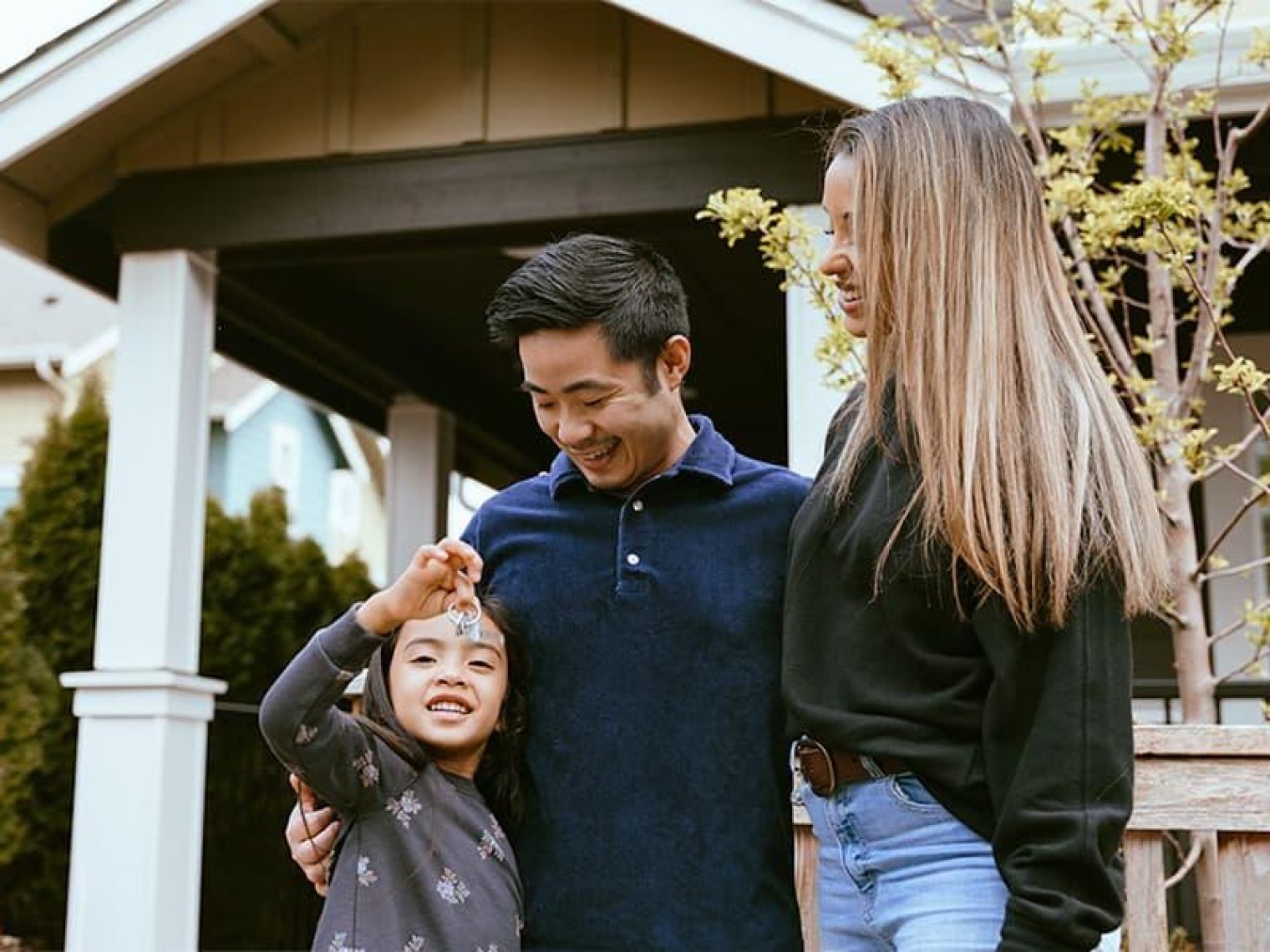 A family standing outside of their new home.