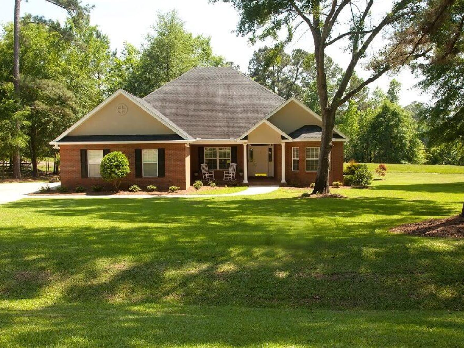 Exterior of a brick home with a large yard.