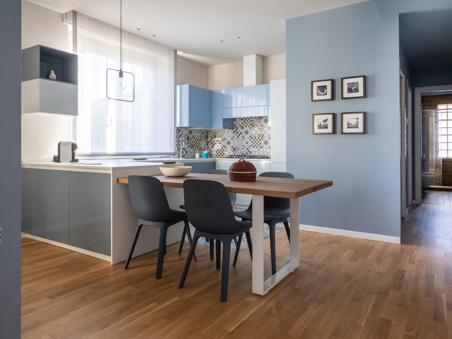 Interior of modern kitchen with wood floors and blue walls.