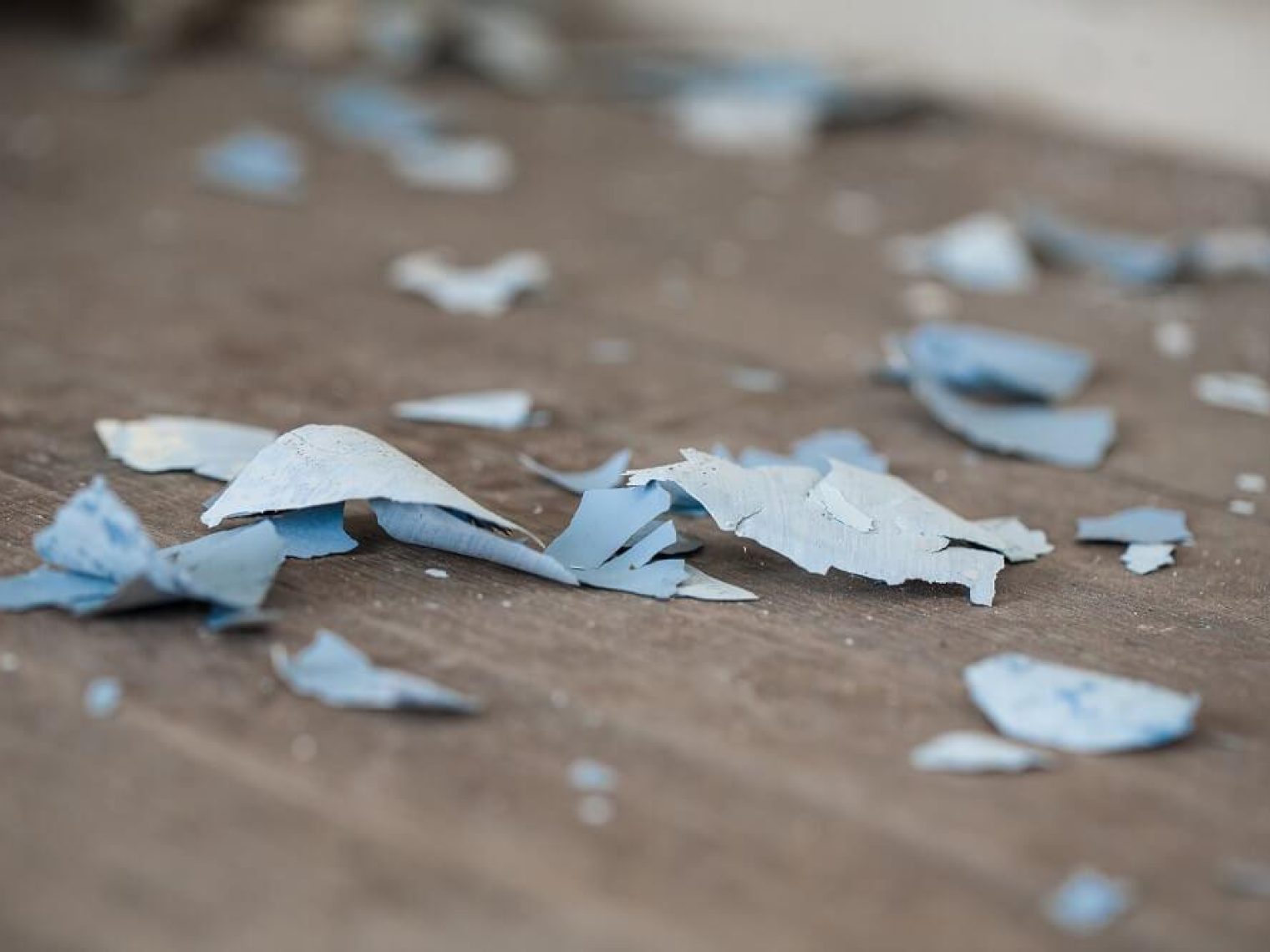 Paint peels on the floor of a home.